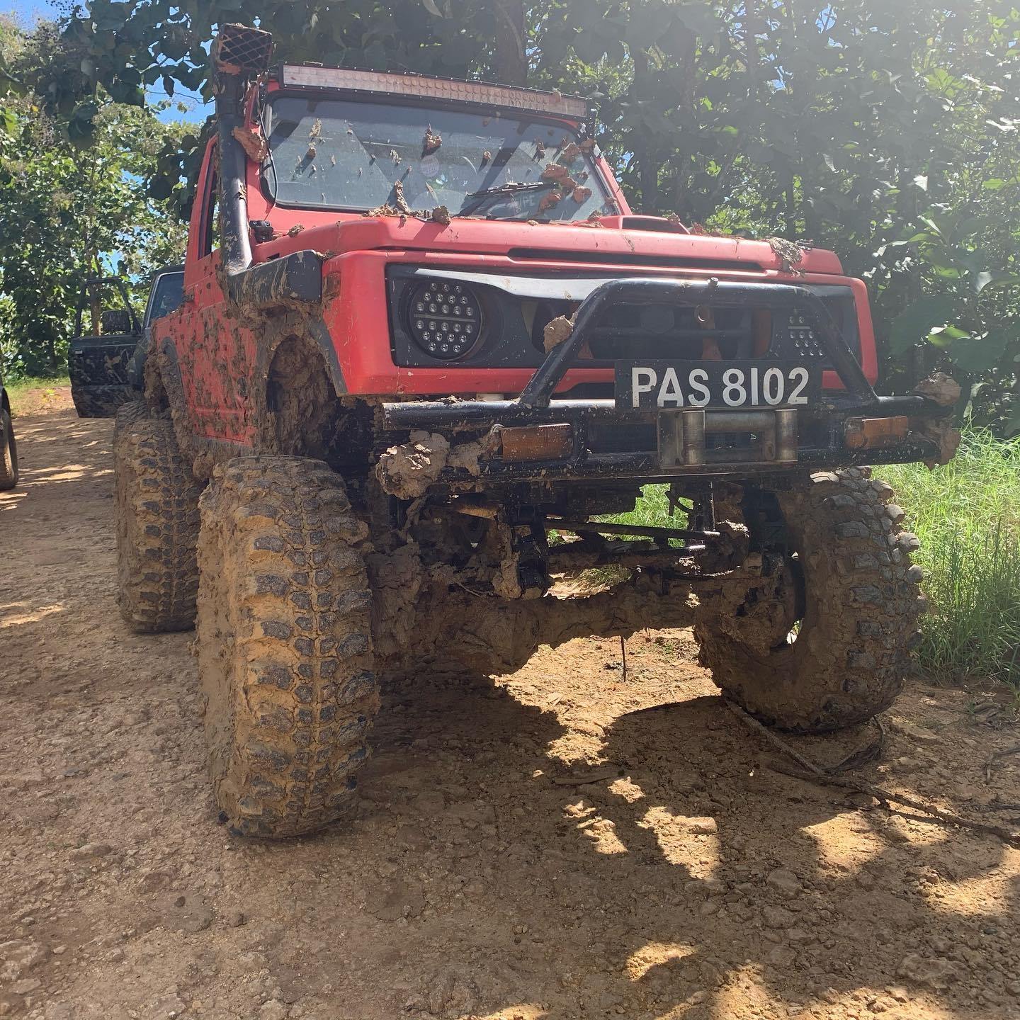 Custom red Suzuki 4x4 truck caked in mud Trinidad